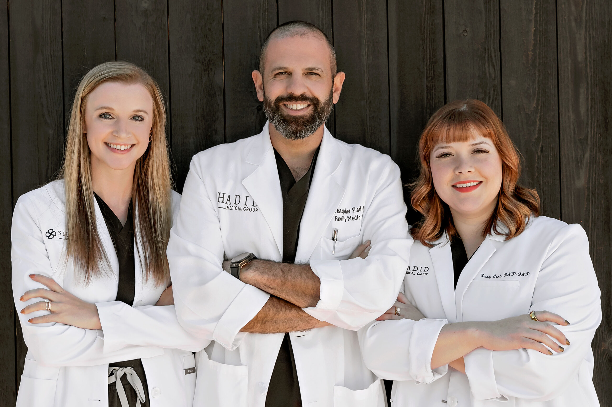 Three doctors posting in white scrubs