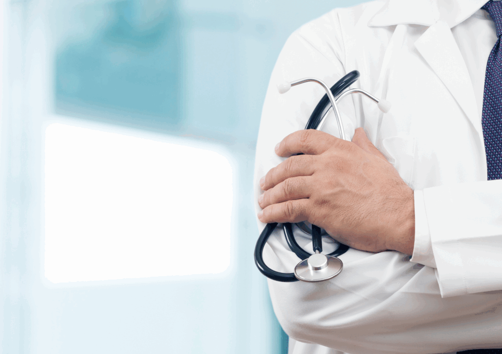 Closeup of doctor's shoulder holding a stethoscope with folded arms.
